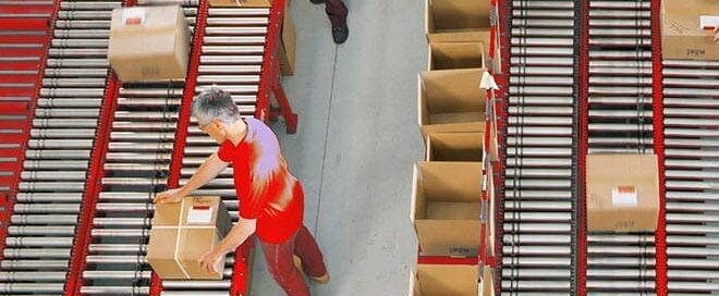 warehouse workers using conveyors to ship packages